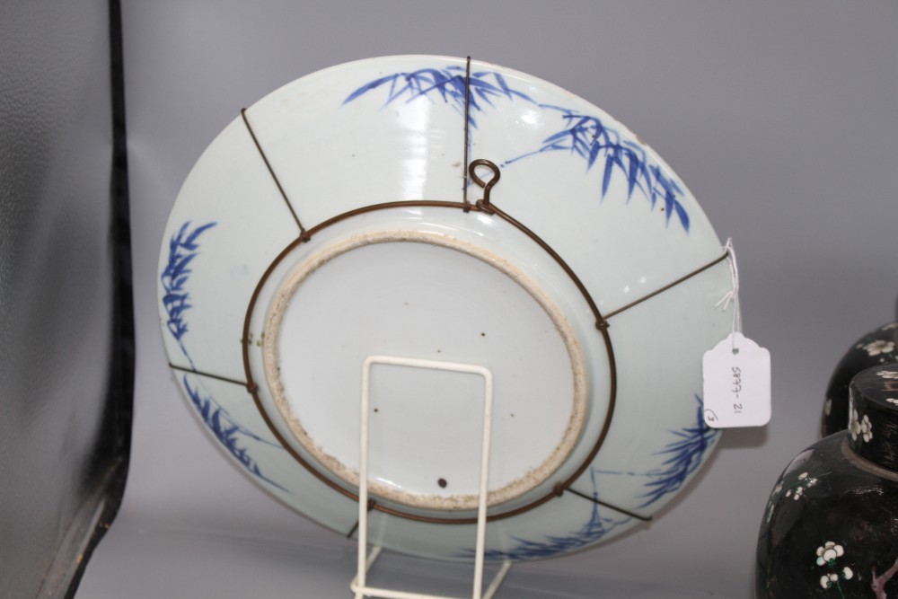 A pair of Chinese famille noire ginger jars and covers, decorated with prunus, height 20cm, and a blue and white dish, 34cm